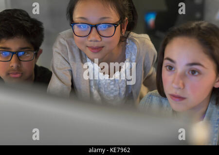 Focused students using computer in dark classroom Stock Photo