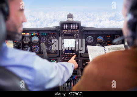 Pilots flying airplane in cockpit Stock Photo