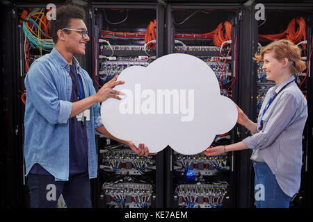 IT technicians holding cloud in server room, cloud computing Stock Photo
