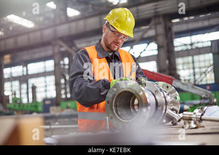 Male worker assembling steel part in factory Stock Photo