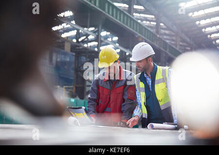 Male engineers using laptop in factory Stock Photo