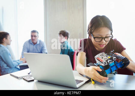 Girl student programming and assembling robotics in classroom Stock Photo
