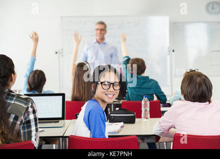 Portrait smiling girl student sitting in classroom during lesson Stock Photo