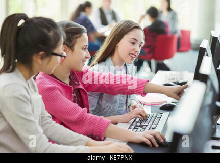 Girl students studying together at computer in library Stock Photo