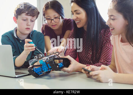 Female teacher and students programming and assembling robotics in classroom Stock Photo