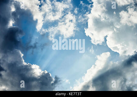 Sun Rays Shining Through The Clouds To The Blue Sky; Canada Stock Photo