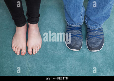 Two Sets Of Feet Viewed From Above, One Barefoot And One In Running Shoes; Connecticut, United States Of America Stock Photo