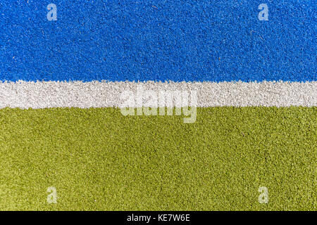 Sports astro synthetic turf field closeup boundary white line with green and blue detail. Stock Photo