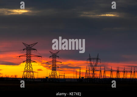 Silhouette Of Large Metal Electrical Towers At Sunset With A Colourful Sky In The Background; Calgary, Alberta, Canada Stock Photo
