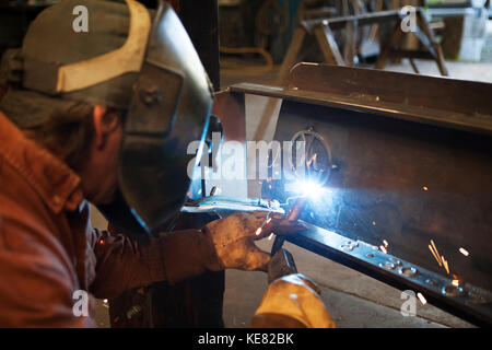 Welder And Metal Work Artist Doug Schwiesow Working On A Custom Sign Designed With A Local Artist For The Kenai Peninsula College Kachemak Bay Campus. Stock Photo