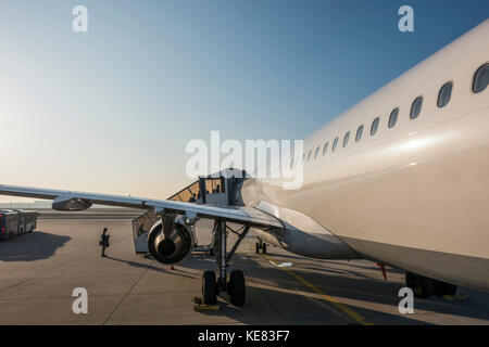 An Airplane Loading Passengers On The Tarmac At Frankfurt Airport; Frankfurt, Germany Stock Photo