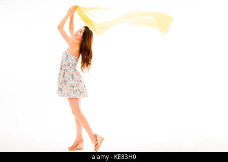 Side view of young smiling woman in summer dress posing fluttering cloth Stock Photo