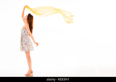 Side view of young smiling woman in summer dress standing fluttering cloth Stock Photo