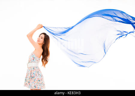 Side view of young smiling woman in summer dress posing fluttering cloth Stock Photo