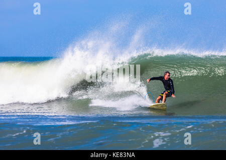 A surfer rides a wave at Pelican Beach on the Atlantic ocean in Florida; Satellite Beach, Florida, United States of America Stock Photo