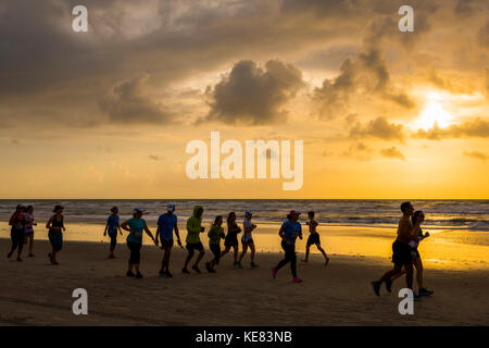 Runners race on the beach at sunrise during the 2017 USA Beach Running Championships; Cocoa Beach, Florida, United States of America