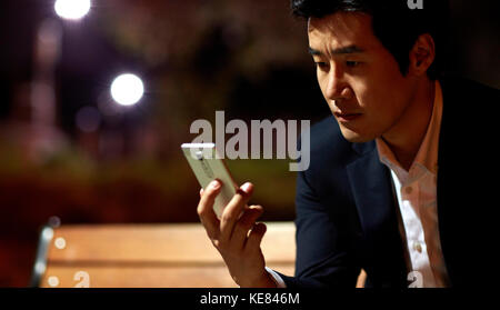 Portrait of businessman tired and gloomy using smartphone at night Stock Photo