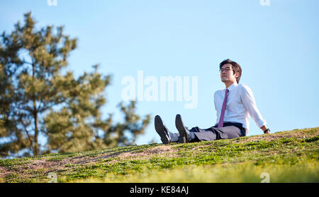 Businessman taking a break at park during daytime Stock Photo