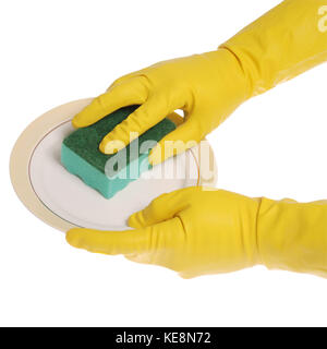 Yellow gloved hands washing a plate with a green sponge. On white background. Clipping path included. Stock Photo
