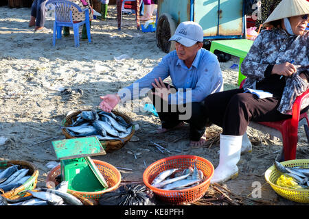 Long Hai beach, Ba Ria Vung Tau, Vietnam. Unidentified woman with traditional clothes and conical leaf hat trading at fish market Stock Photo