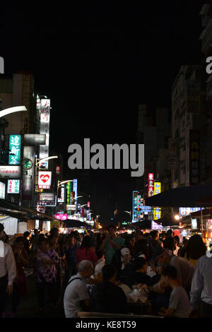 A tourist eating at the Liuhe night market in Kaohsiung, taken in July 2017 Stock Photo