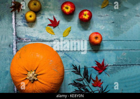 Autumn produce. Pumpkin, apples and leaves on a pale blue wooden background Stock Photo