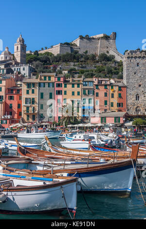 The harbour at Portovenere, on the coast of Liguria, North West Italy. Doria Castle is on the background, behind rows of colourful terraced houses Stock Photo