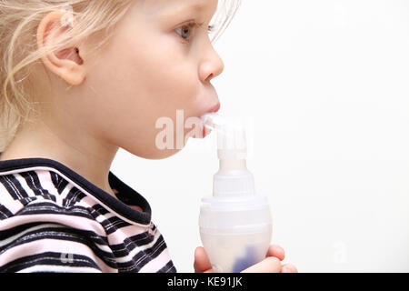 Child using inhaler isolated on white background. Theme of treatment of children's respiratory illness. Stock Photo