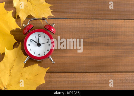 Top view of red vintage alarm clock on wooden background. Time change concept. Stock Photo