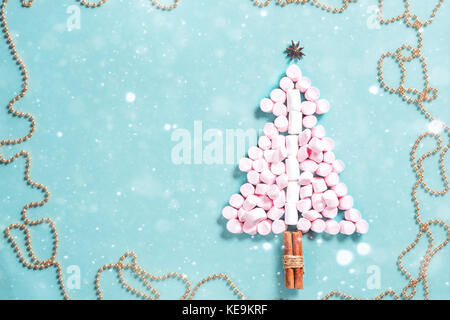 Fir tree silhouette from pink marshmallows on blue background Stock Photo
