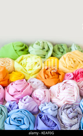 Accessories for sewing lie on a white background. Measuring tape, thread, fabric and needles for sewing. Color fabric. Stock Photo