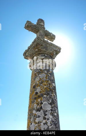 Old granite cross called humilladero at Trujillo outskirts,  Spain. Backlit Stock Photo