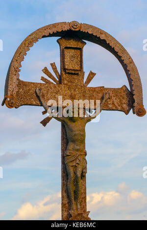 Old statue of Jesus Christ, Christian religious theme. Rusty bronze statue of Jesus statue, blue sky, symbol of Christianity. Stock Photo