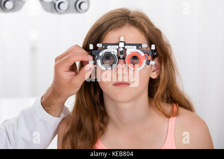 Close-up Of An Optometrist Checking Girl's Vision With Trial Frame At Eye Clinic Stock Photo