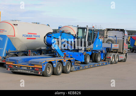 SALO, FINLAND - APRIL 15, 2016:  Terex Fuchs MHL 320 material handler on Scania semi trailer, parked on truck stop, back and side view. Stock Photo