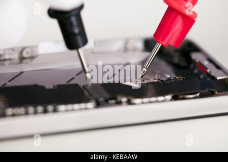Close-up Of Multimeter Probes Testing Mobile Phone Stock Photo