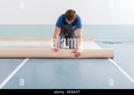 Portrait Of Happy Young Man Laying Carpet On Floor At Home Stock Photo