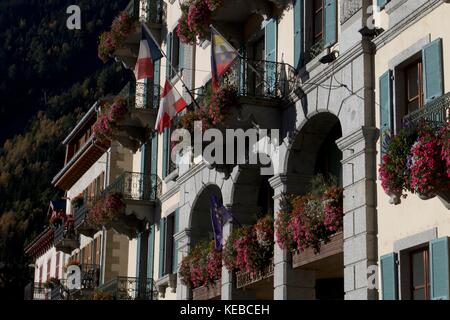 Detail of hotel facade with flowering window boxes and Swiss and French flags, Chamonix-Mont-Blanc, France Stock Photo