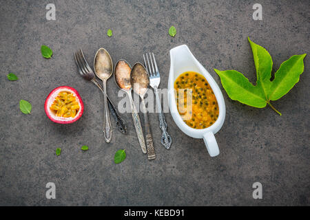 Fresh passion fruits set up on dark stone background. Passion fruits and juice with pepper mint leaves. Healthy food backgroud concept. Stock Photo