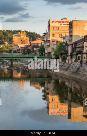 Reflections of the buildings on the banks of the Miyagawa River in Takayama at sunset Stock Photo