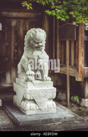 A Komainu guards a shinto shrine in Kyoto Stock Photo