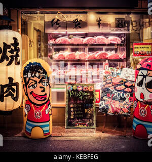 The bright window of a butchers shop in downtown Osaka drawing in customers Stock Photo