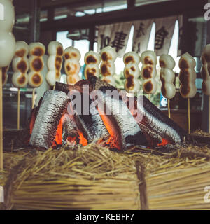 Japanese sweet dumplings made from mochiko, rice flour, cooking on an open fire. Stock Photo