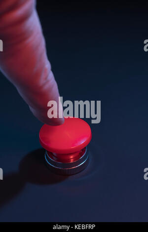 Big red button - metaphor for 'Finger on the Button'. Photographer's hand in shot (see additional info re. MR) Stock Photo