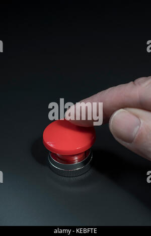 Big red button - metaphor for 'Finger on the Button'. Photographer's hand in shot (see additional info re. MR) Stock Photo