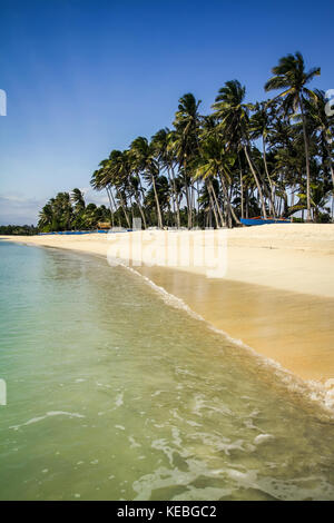 White sand beach in the Philippines. Saud beach palm fringed idyllic tropical getaway paradise with transparent sea and clean undeveloped beach Stock Photo