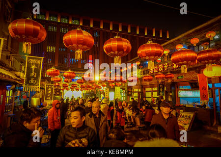 BEIJING, CHINA - 29 JANUARY, 2017: People walking around charming streets with small restaurants, traditional architecture and decorations, local Donghuamen food market concept Stock Photo