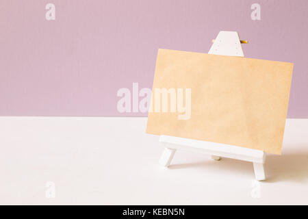 Empty paper on white painted wooden easel Stock Photo