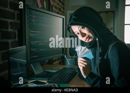 attractive beauty girl hacker stealing many credit card and using online code system to get account password preparing blackmail money. Stock Photo
