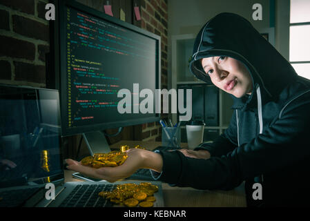 beautiful young female hacker using online virus code language system doing fraud work and getting many golden bitcoin feeling happy. Stock Photo